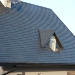 Hosekra Blechdach in Antrazit Farbe mit Giebel und Schwarzen Dachrinne.