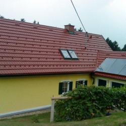 Sateldach mit Dachdeckung Hosekra Glatt mit Dachfenster und Solarmodulen. Dach für Glück