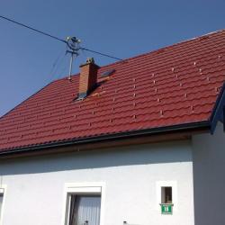 Rotes Hosekra Dachpfane am Satteldach mit Dachkamin und Dachfenster.