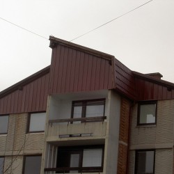 Dachdeckung Hosekra Glatt Dachpfanne, Wandverkleidung mit Trapeze und Dachkamin.