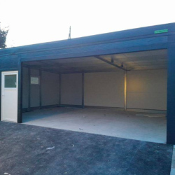Antracit kovinska garaža z belimi vrati in širokim vhodom