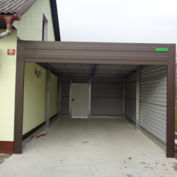 Rjava kovinska garaža Hosekra ob hiši