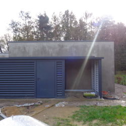 Sodobna ozka kovinska lopa Hosekra ob objektu