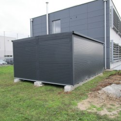 K110 Dvojini montažni kontejner Hosekra v antracit barvi postavljen ob objekt.