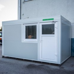 Manjši bel kontejner Hosekra ob proizvodni hali