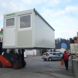 Transport z viličarjem belega montažnega kontejnerja Hosekra